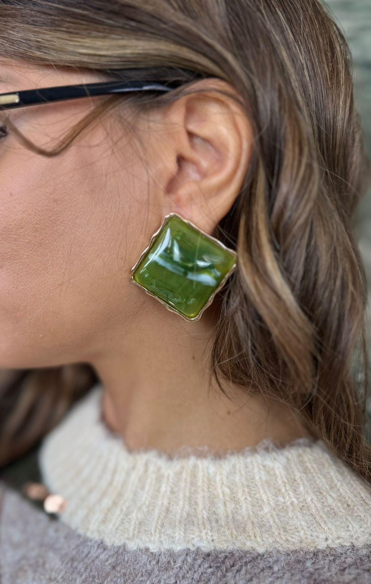 Orecchini a bottone con pietra incastonata in una montatura color oro