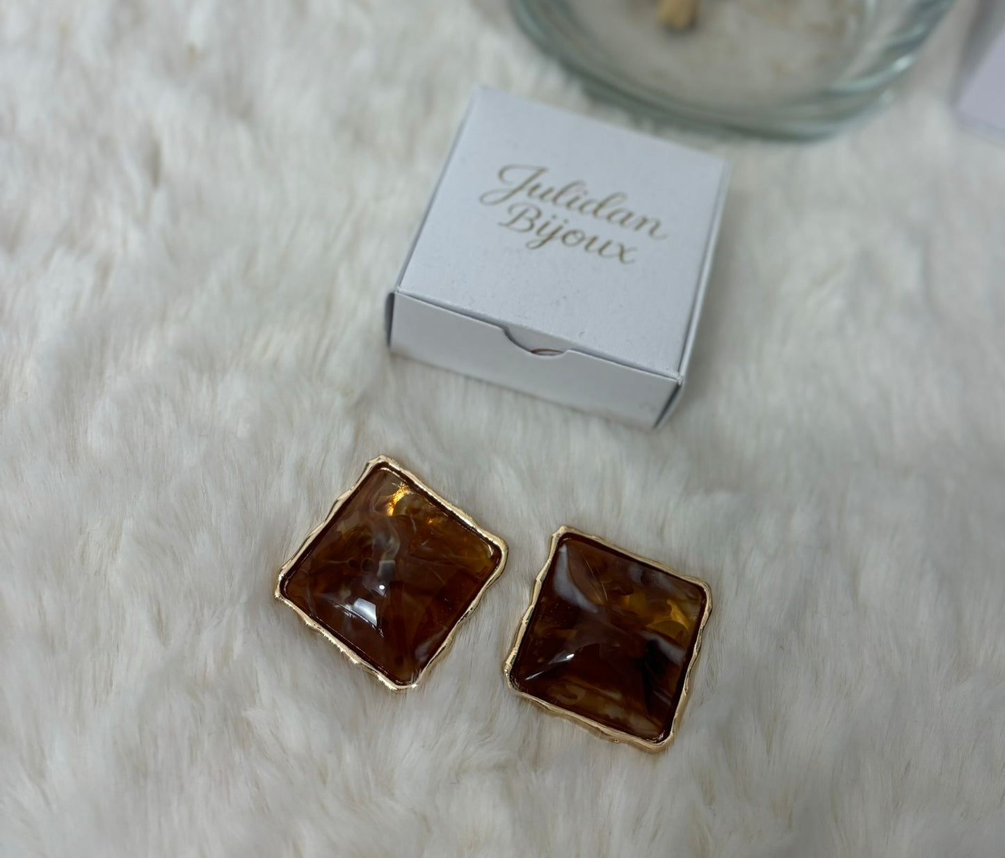 Orecchini a bottone con pietra incastonata in una montatura color oro